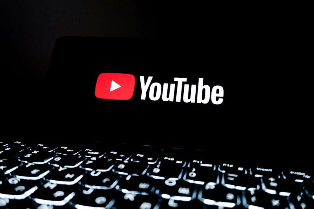 Youtube logo displayed on a dark screen above keyboard
